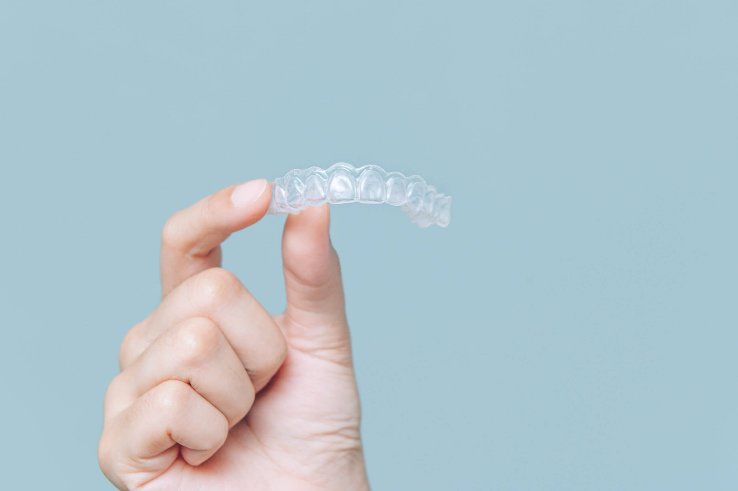 Woman show orthodontic silicone trainer. Mobile orthodontic appl